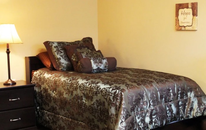 A neatly arranged bed with luxurious bedding and pillows.