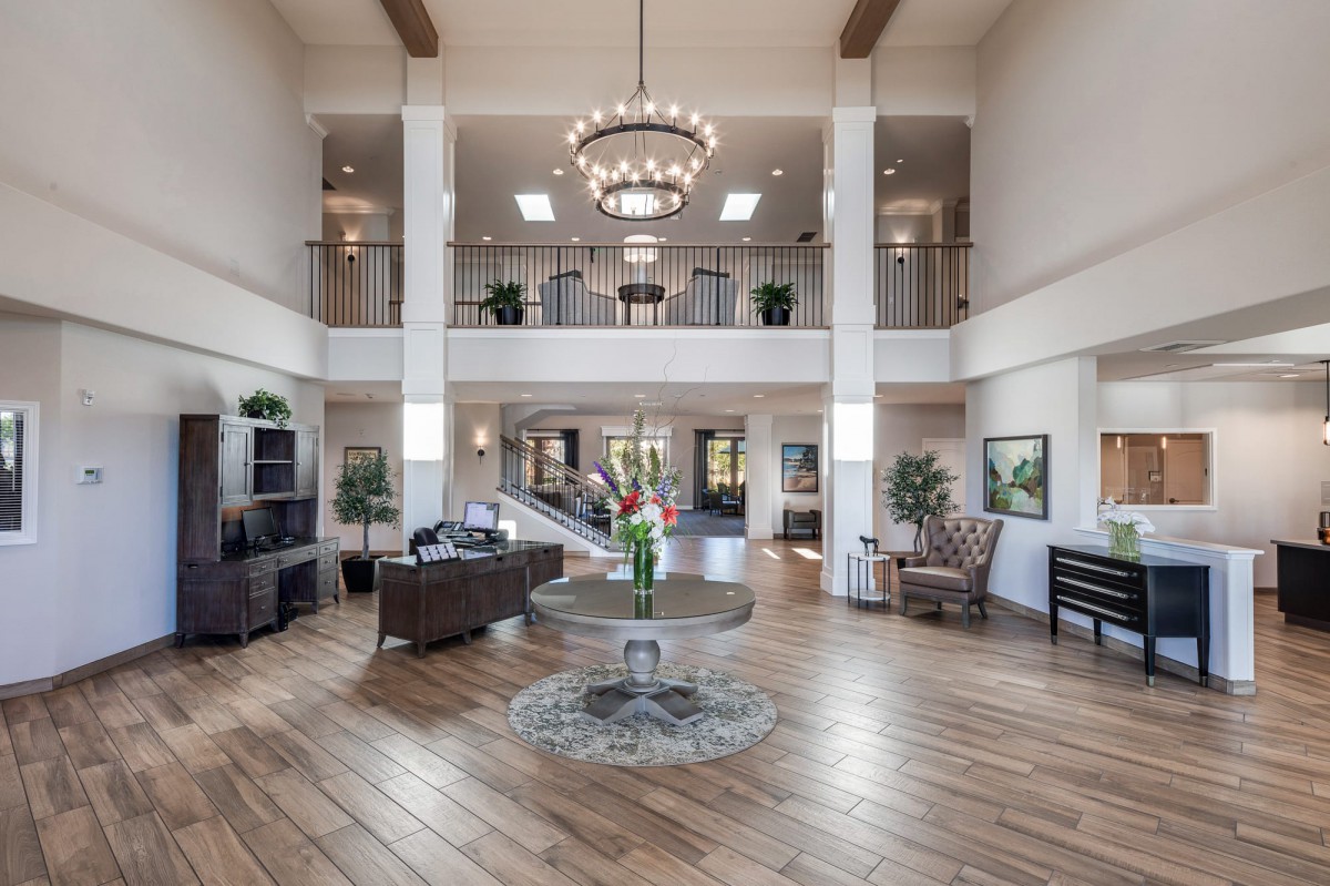 Spacious and elegant lobby with modern decor and a grand chandelier.