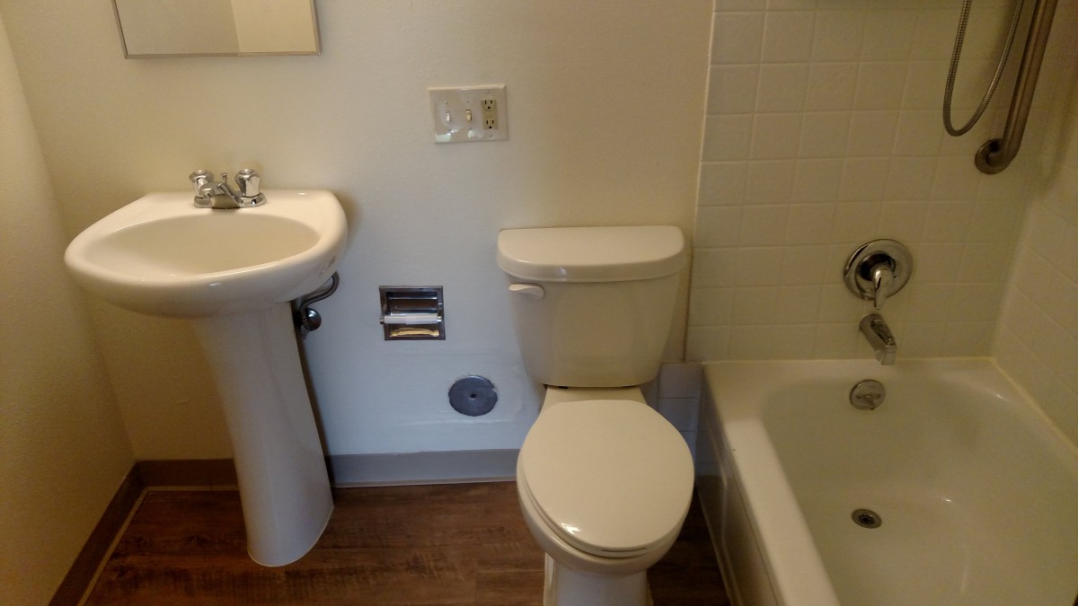 A compact bathroom with a toilet, sink, and bathtub.