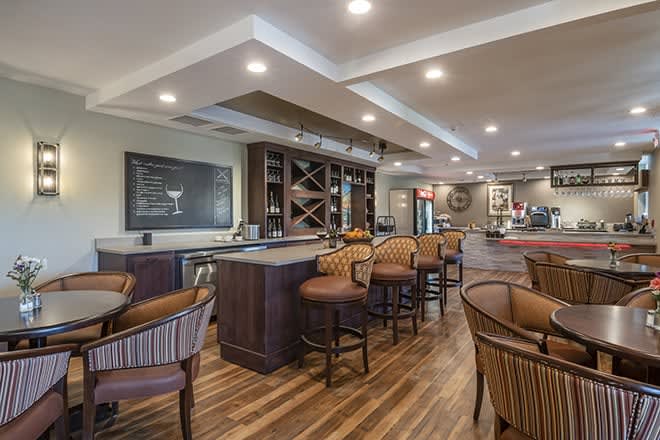 A cozy bar interior with wooden flooring and ample seating.