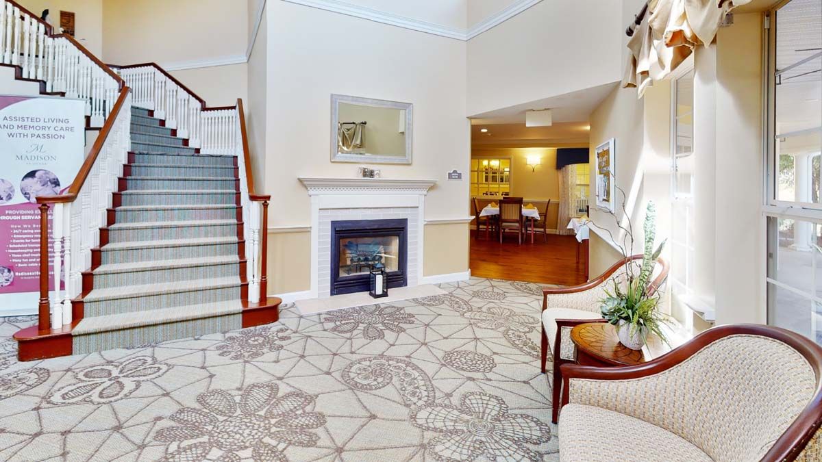 A modern living room with a fireplace and elegant staircase.