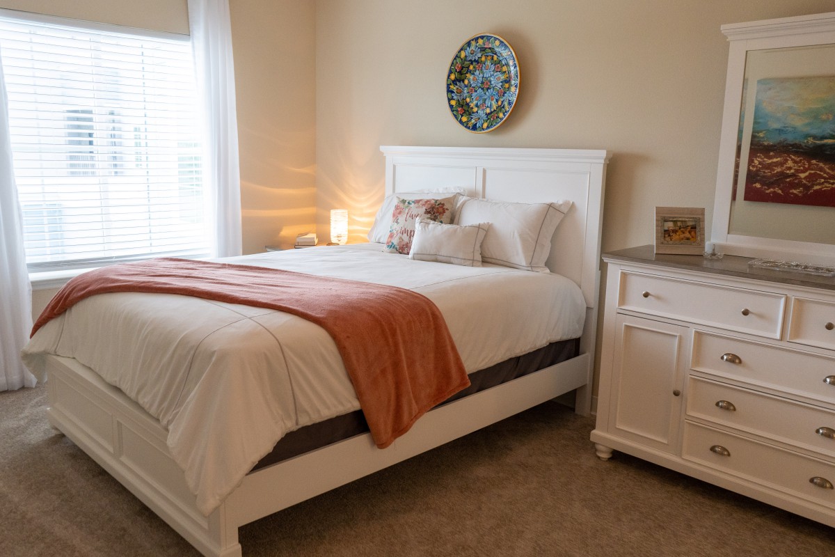 A cozy bedroom with a neatly made bed and elegant decor.