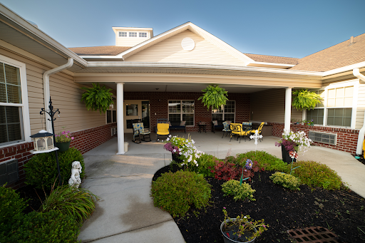 A welcoming exterior view of a building featuring a charming porch and vibrant landscaping.