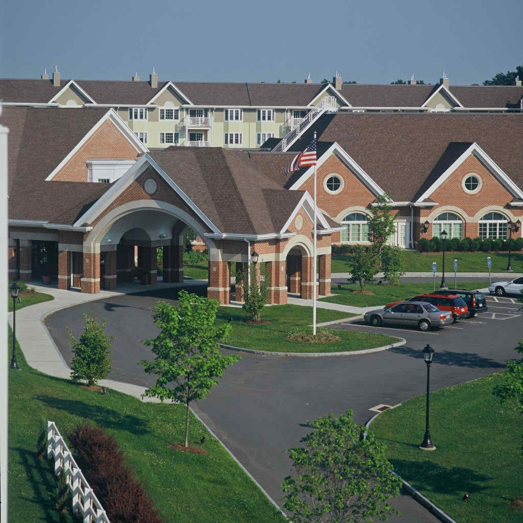 A well-maintained residential complex with landscaped surroundings and parking area.