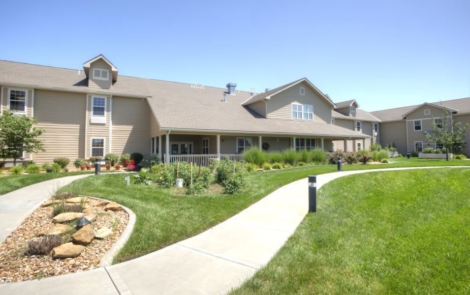 A large residential building with a well-maintained lawn and pathway.
