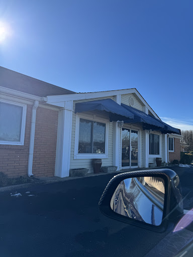 A clear view of a building with a blue awning on a sunny day.
