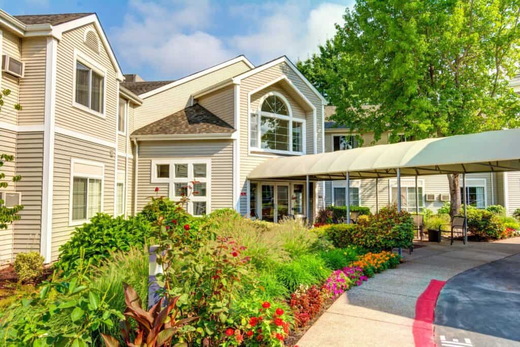 A beautiful residential house with well-maintained landscaping and a colorful garden.