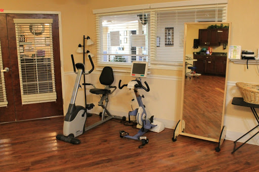 A cozy home gym featuring an exercise bike, an elliptical machine, and a large mirror for workouts.