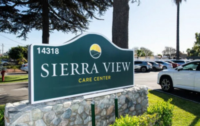 Sign for Sierra View Care Center with a view of the parking area.