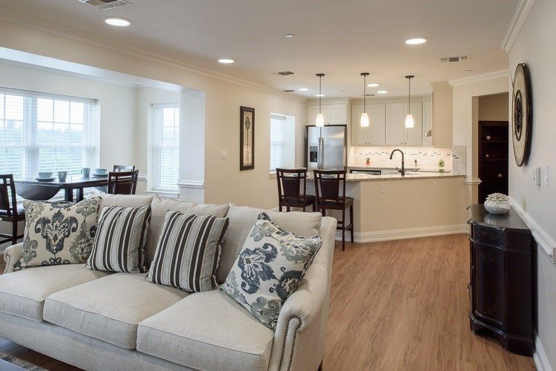 A modern open floor plan featuring a cozy living room and sleek kitchen with wood flooring.