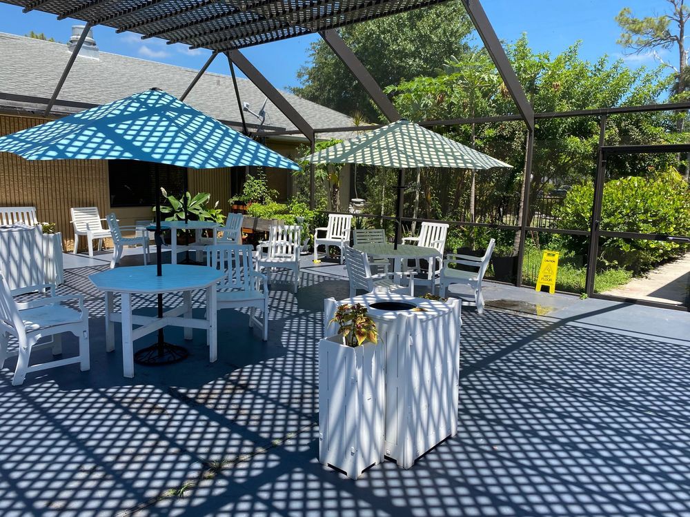 A sunny outdoor patio with umbrellas and seating arrangements.