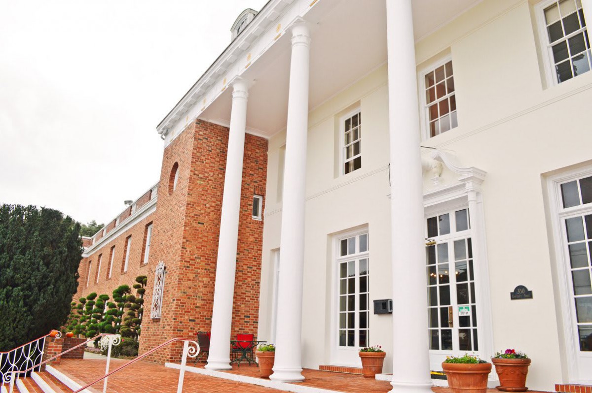 A building with classic architecture featuring white columns and a brick facade.