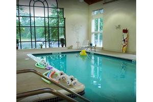 An inviting indoor swimming pool with floaties and natural light.