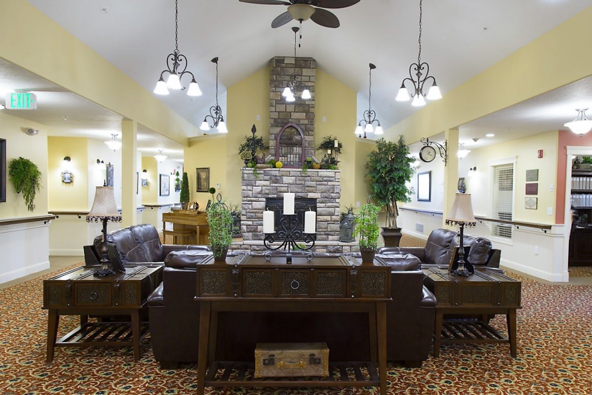 A cozy living room with a stone fireplace, comfortable seating, and elegant lighting.