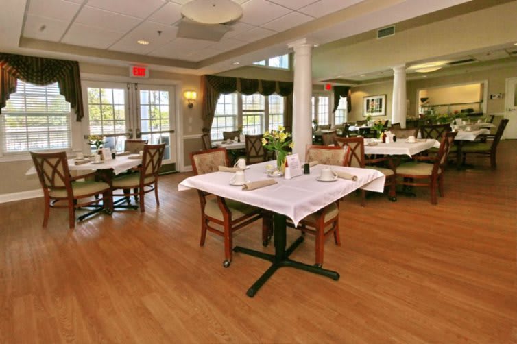 A spacious and elegantly decorated restaurant dining area with neatly arranged tables and chairs.