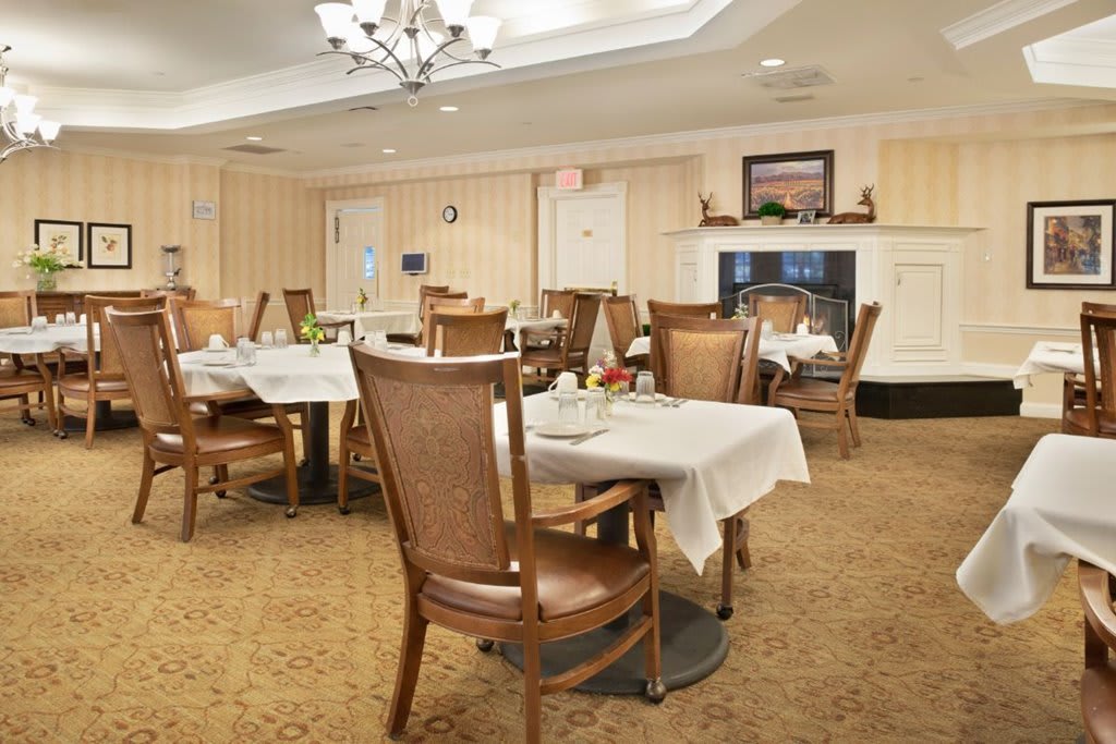 A cozy dining room with elegantly set tables and wooden chairs.