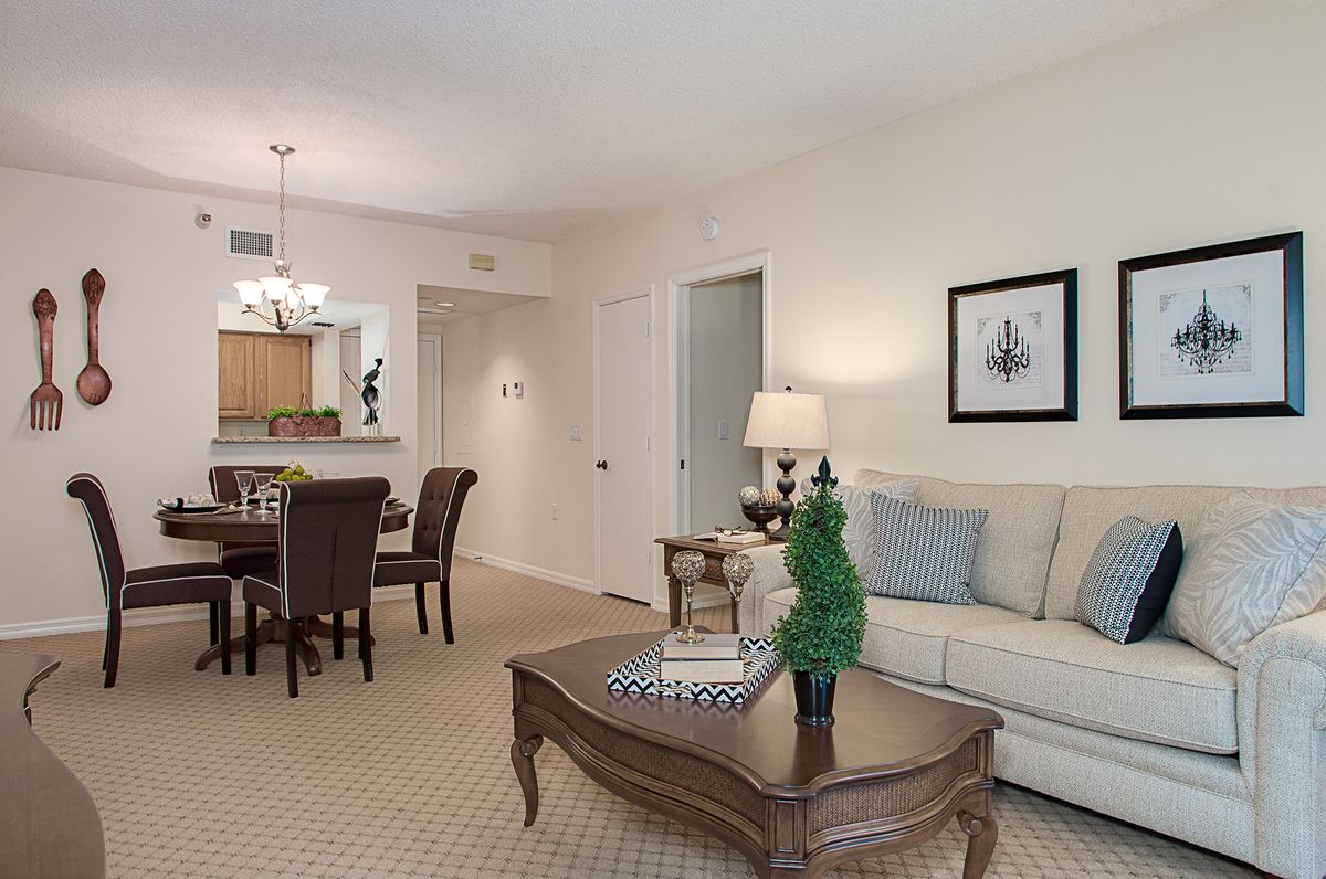 A cozy living room with a dining area, featuring a sofa, coffee table, and elegant decor.