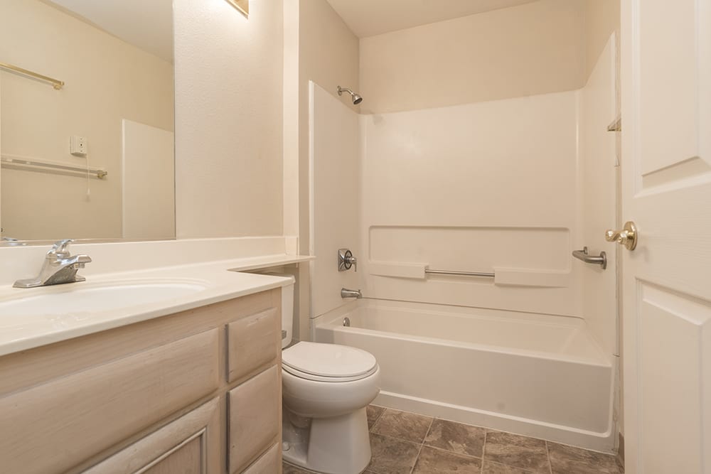 A clean and simple bathroom with a bathtub, toilet, and vanity sink.