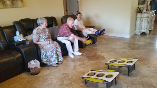A group of elderly individuals enjoying a game in a comfortable indoor setting.