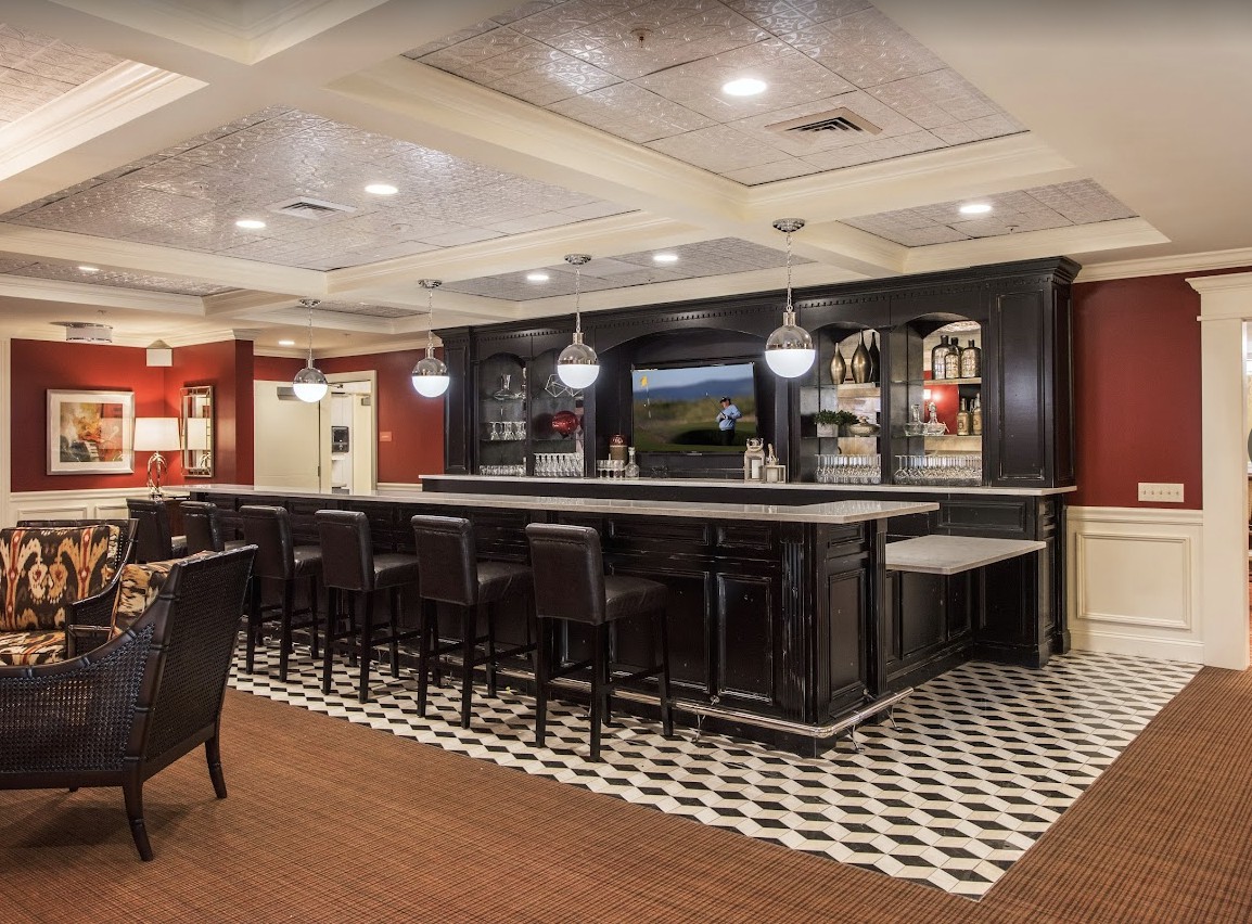 A modern bar area with seating and stylish lighting.