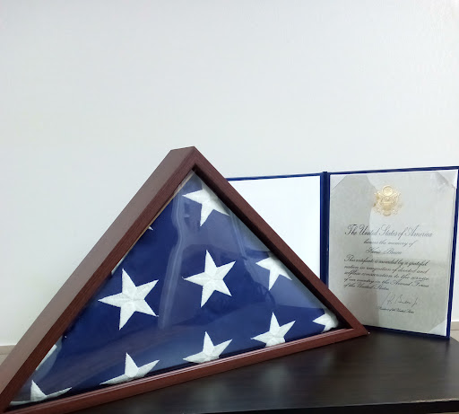 A framed American flag alongside a certificate, symbolizing honor and remembrance.