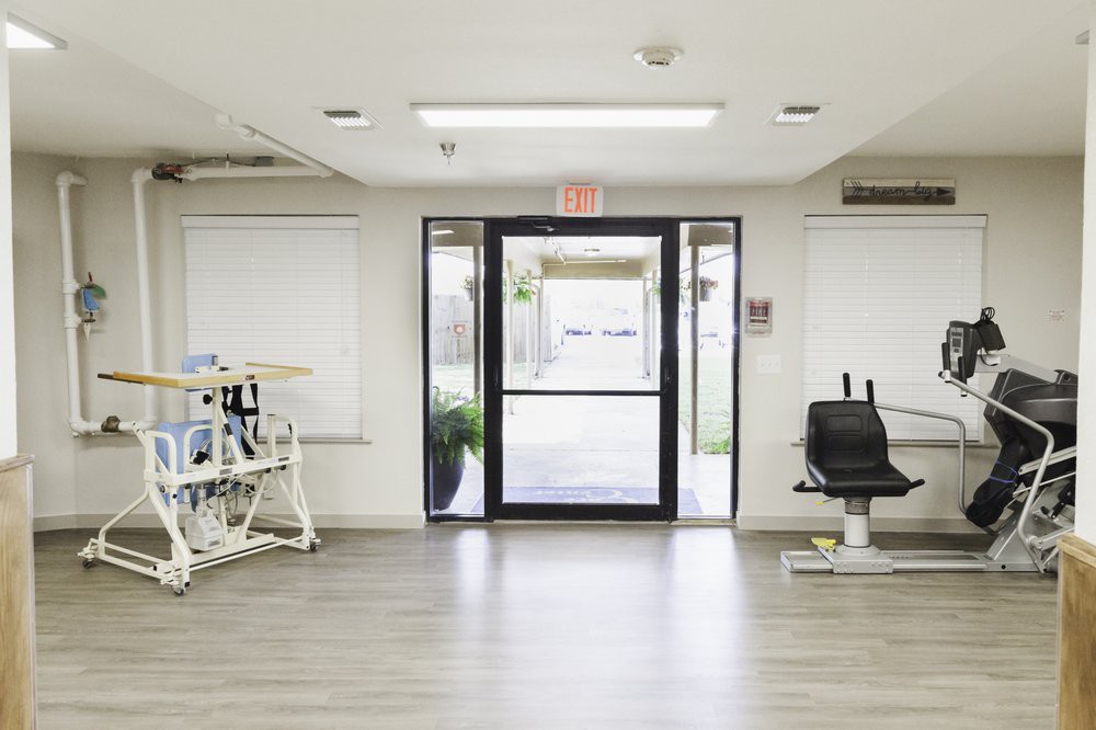 An empty medical clinic interior with a waiting area and examination equipment.