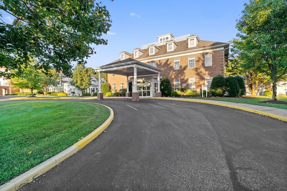 A brick building with a driveway and landscaped surroundings.