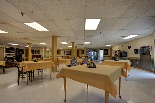 A spacious dining area with neatly set tables and warm lighting, creating an inviting atmosphere.