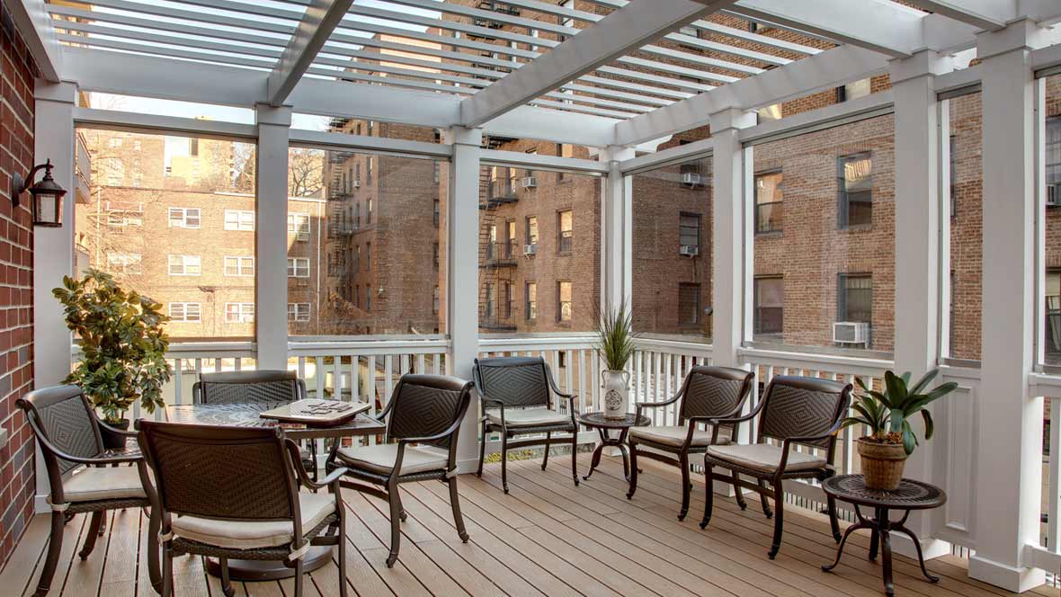 An urban deck with a pergola and comfortable seating, ideal for relaxing outdoors.