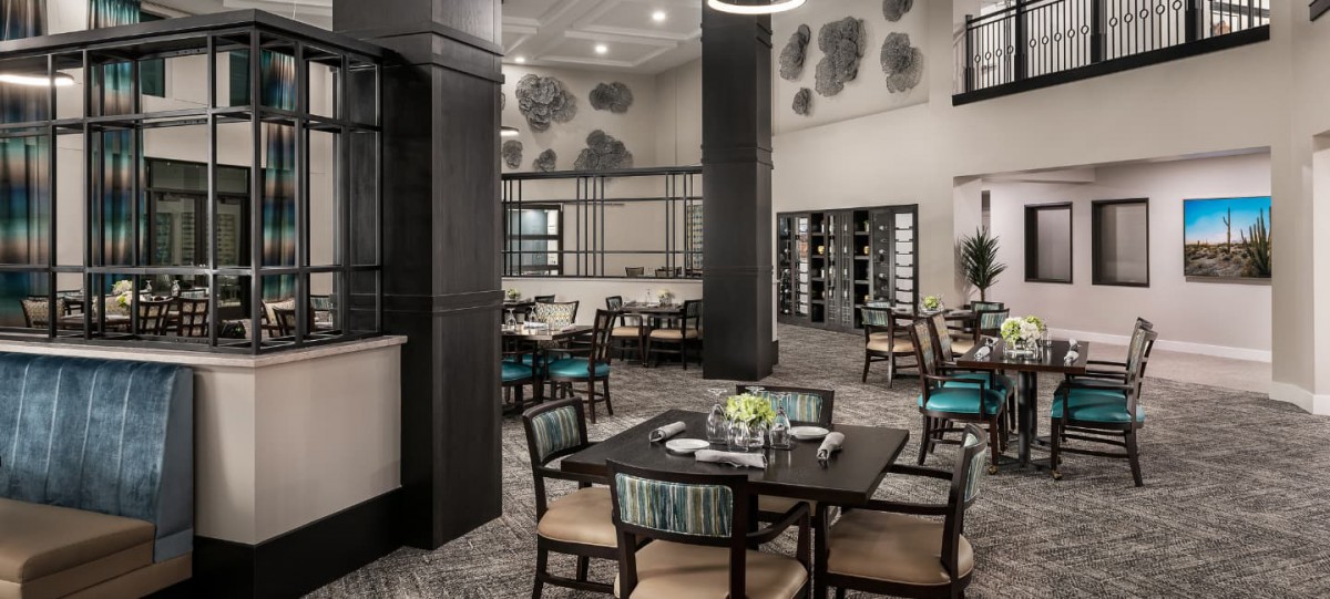 A modern restaurant interior with neatly arranged tables and ambient lighting.