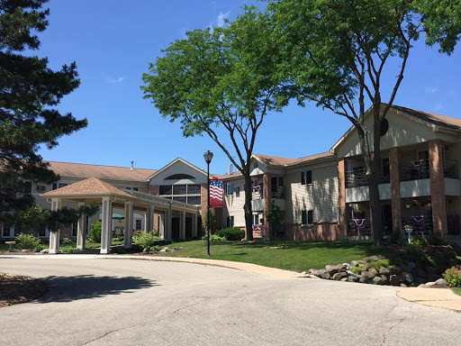 A view of a residential complex featuring well-maintained landscaping and a clear blue sky.