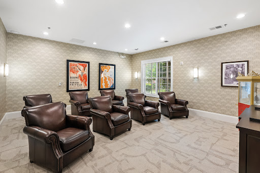 A cozy waiting area featuring plush leather chairs and artistic decor.