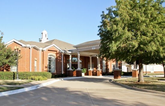 A charming brick building with a welcoming entrance and surrounding greenery.