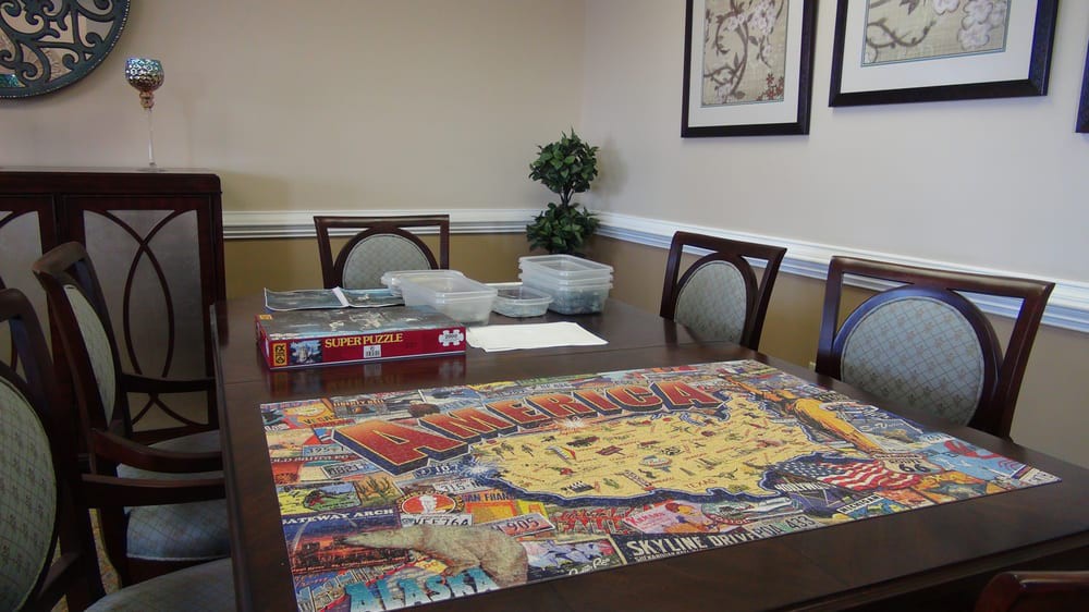 A completed jigsaw puzzle on a table in a dining room.