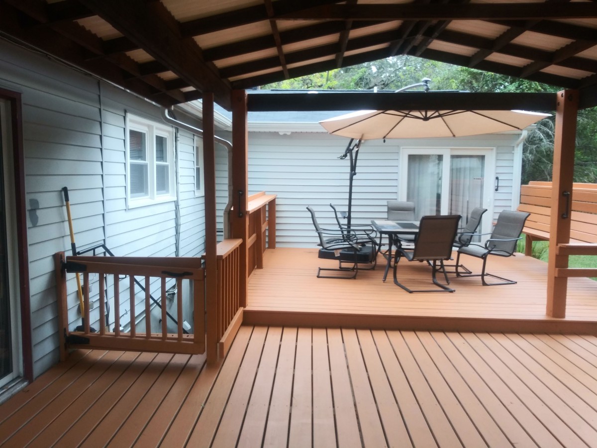 A spacious backyard deck with outdoor furniture and a covered area.