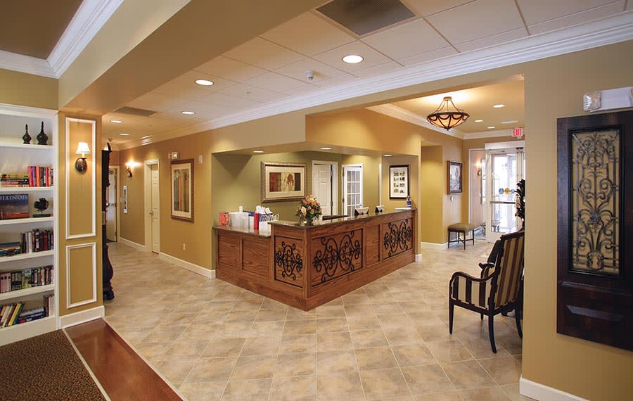 A well-lit office lobby with a reception desk and seating area.
