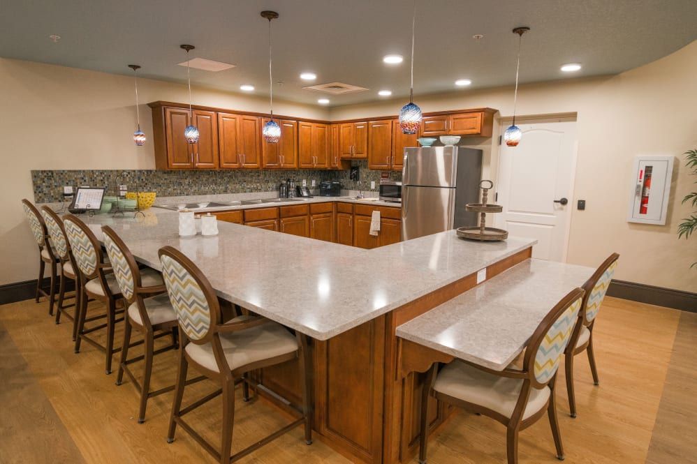 A modern kitchen with a large island, wood cabinets, and stainless steel appliances.