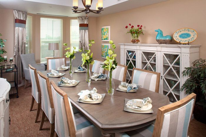 A beautifully set dining room with elegant place settings and floral arrangements.