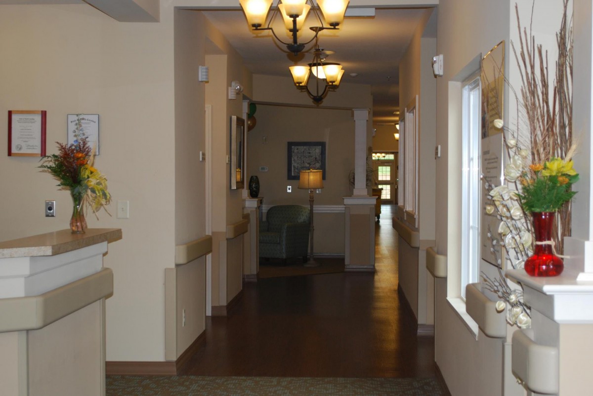 A well-lit hallway with a chandelier and interior furnishings.