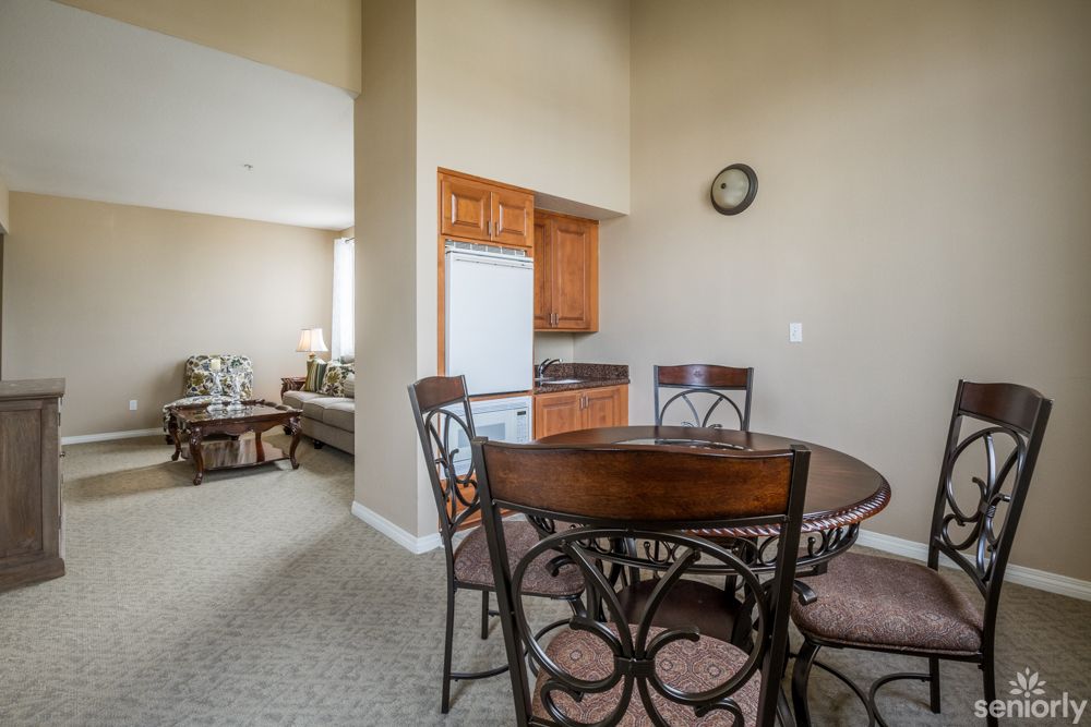 A cozy dining area with a wooden table and chairs adjacent to a compact kitchen.