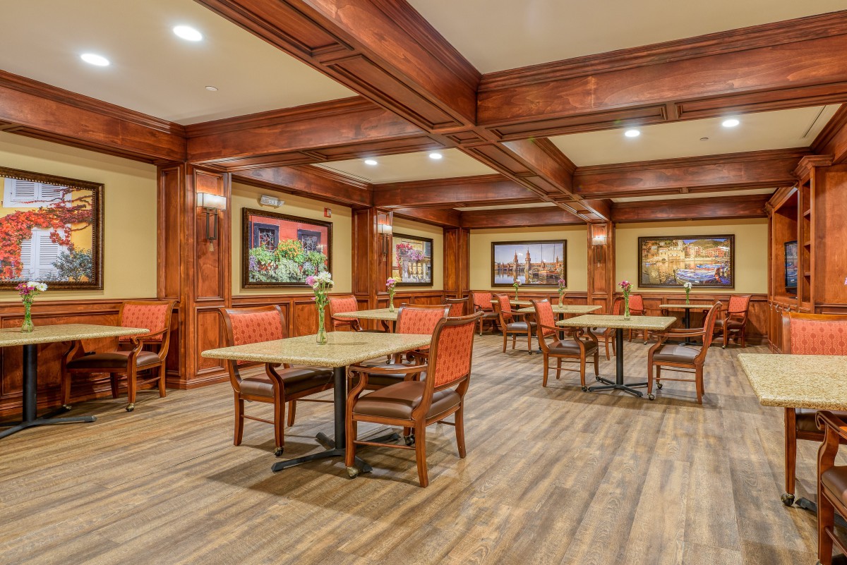 An elegant dining room with wooden interiors and decorative paintings.