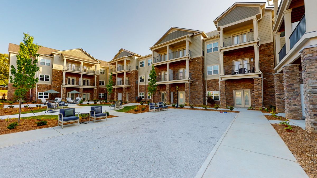 A modern apartment complex with balconies and outdoor seating areas.