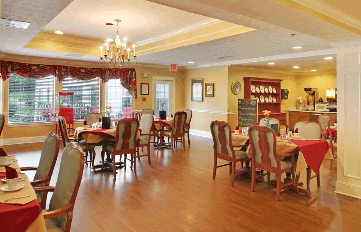 A cozy dining room with elegant furniture and a chandelier.