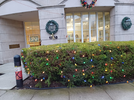 A festive building entrance adorned with Christmas lights and a decorative wreath.
