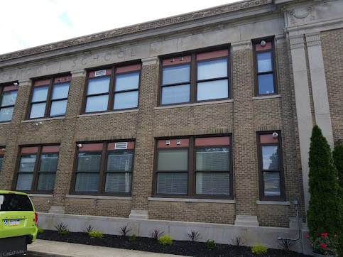 A two-story brick building with large windows and classical architectural details.