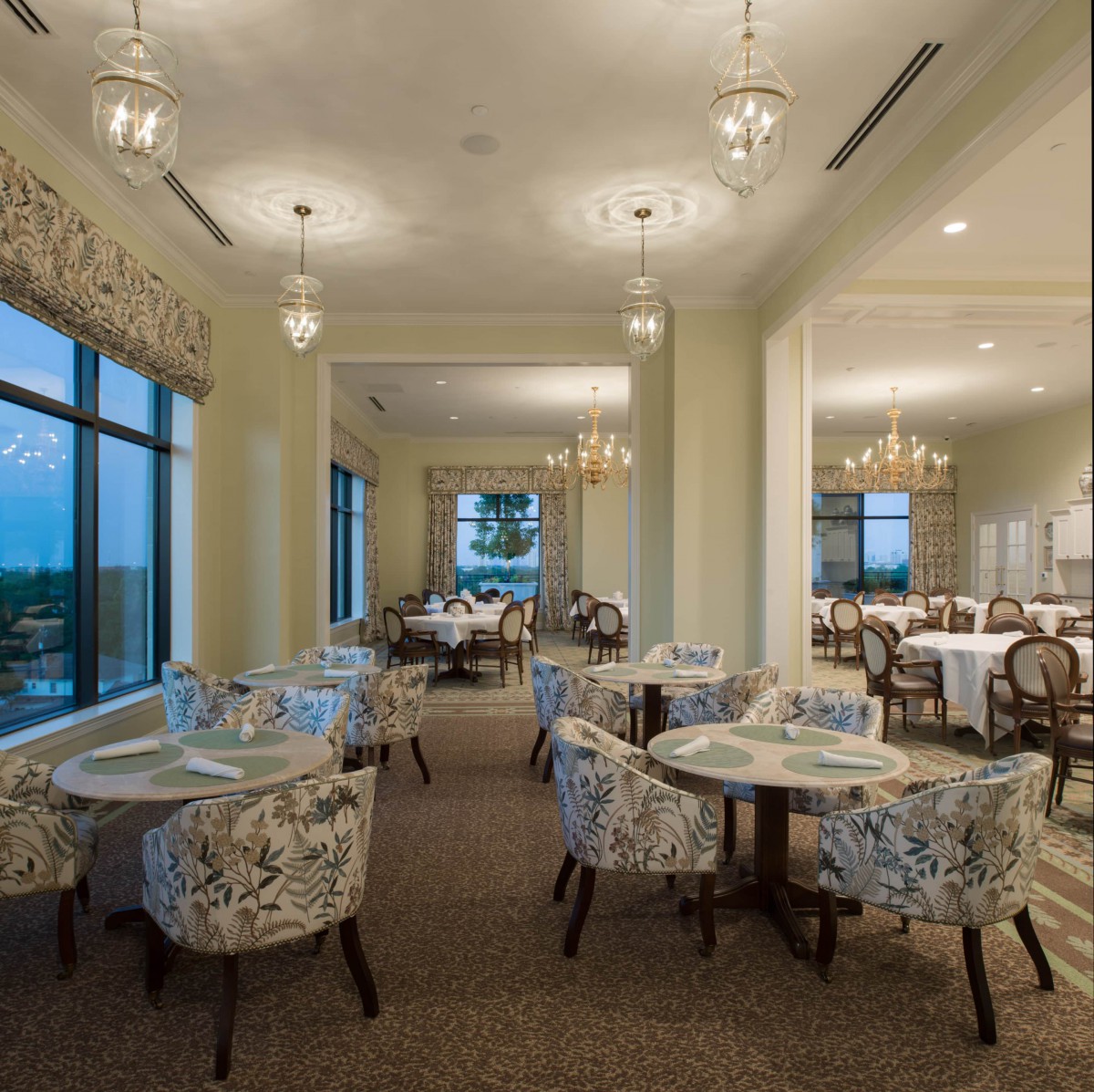 An elegant dining area with chandeliers and large windows providing a scenic view.