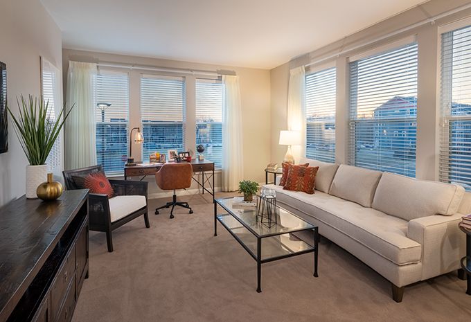 A modern living room with a comfortable sofa, large windows, and well-placed furniture.
