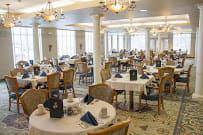 An elegant dining room with neatly arranged tables and chairs.