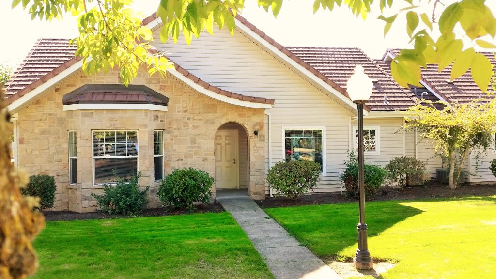 A charming house with a well-maintained lawn and a lamp post by the pathway.