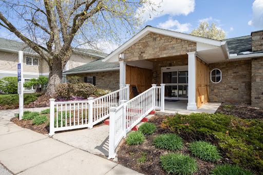 A welcoming entrance featuring a ramp for accessibility, surrounded by well-maintained landscaping.
